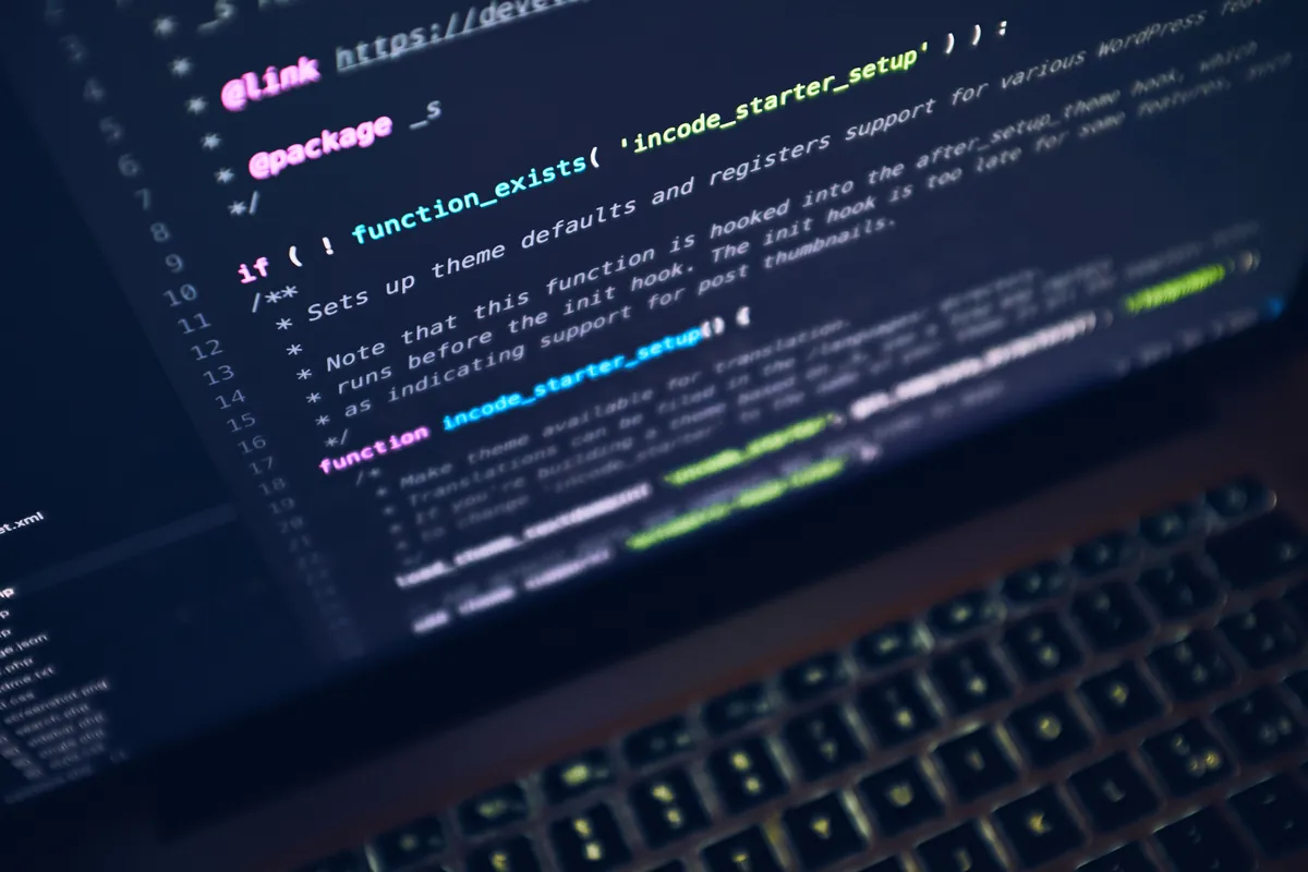 Close-up of a laptop screen showing hand-written website source code